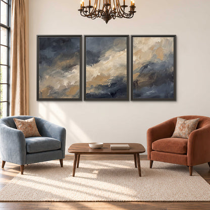 Sweeping charcoal and cream painted clouds with warm gold tones 3 piece framed canvas wall art styled in an interior