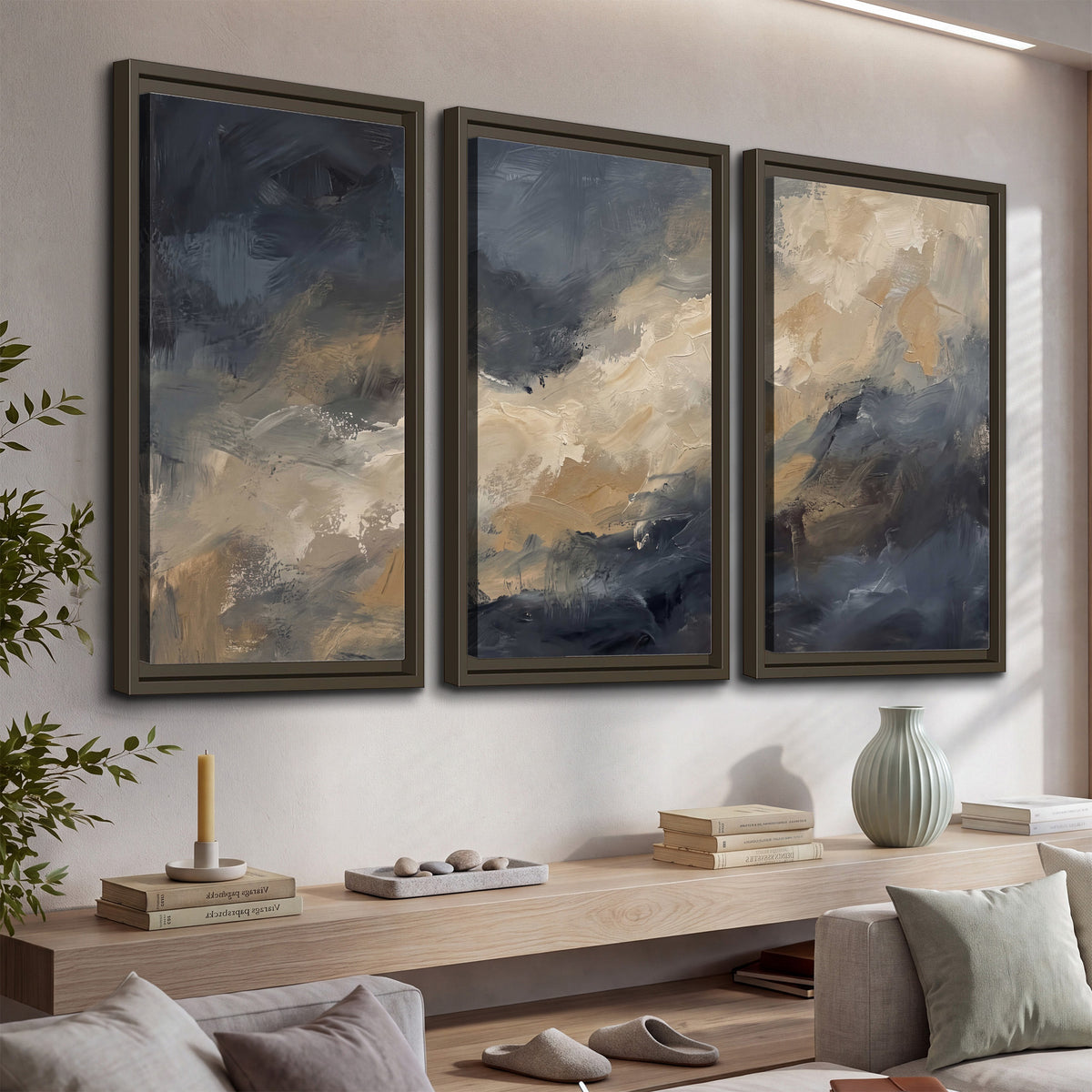 Sweeping charcoal and cream painted clouds with warm gold tones 3 piece framed canvas wall art displayed in a console