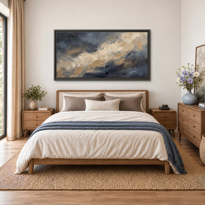 Sweeping charcoal and cream painted clouds with warm gold tones single framed canvas wall art styled in an interior