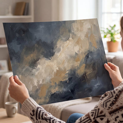 Sweeping charcoal and cream painted clouds with warm gold tones single poster print held in hands