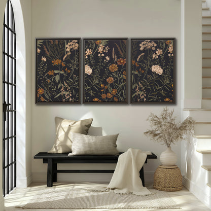 Small cream and rust flowers on a dark botanical background 3 piece framed canvas wall art displayed in a entryway