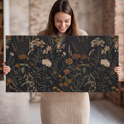 Small cream and rust flowers on a dark botanical background single canvas wall art held in hands
