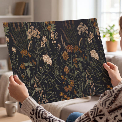 Small cream and rust flowers on a dark botanical background single poster print held in hands