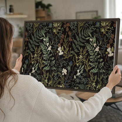 Fine green ferns and cream flowers on a black background single framed canvas wall art held in hands
