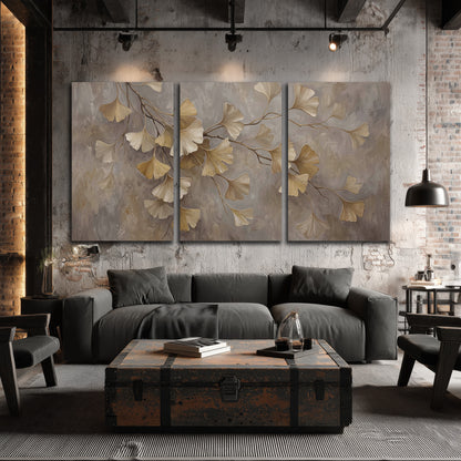 Cream and gold-colored ginkgo leaves against warm gray 3 piece canvas wall art displayed in a industrial room