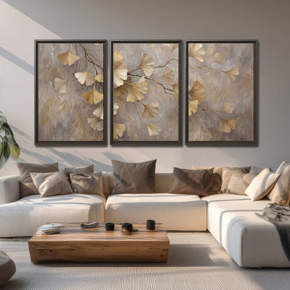 Cream and gold-colored ginkgo leaves against warm gray 3 piece framed canvas wall art displayed in a living room