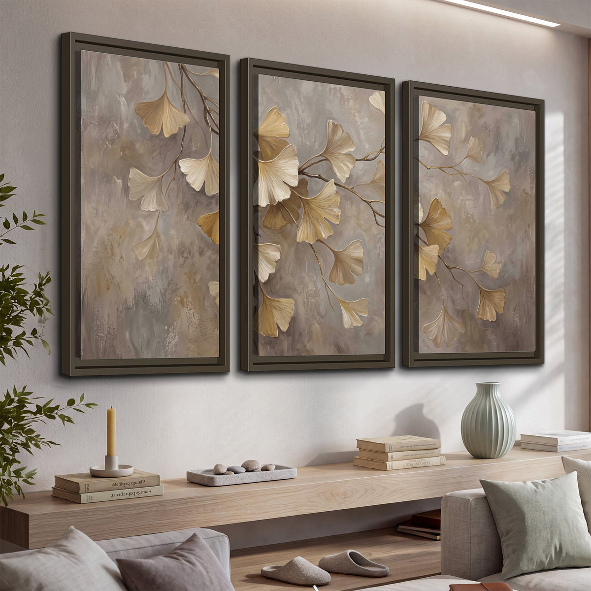 Cream and gold-colored ginkgo leaves against warm gray 3 piece framed canvas wall art displayed in a console