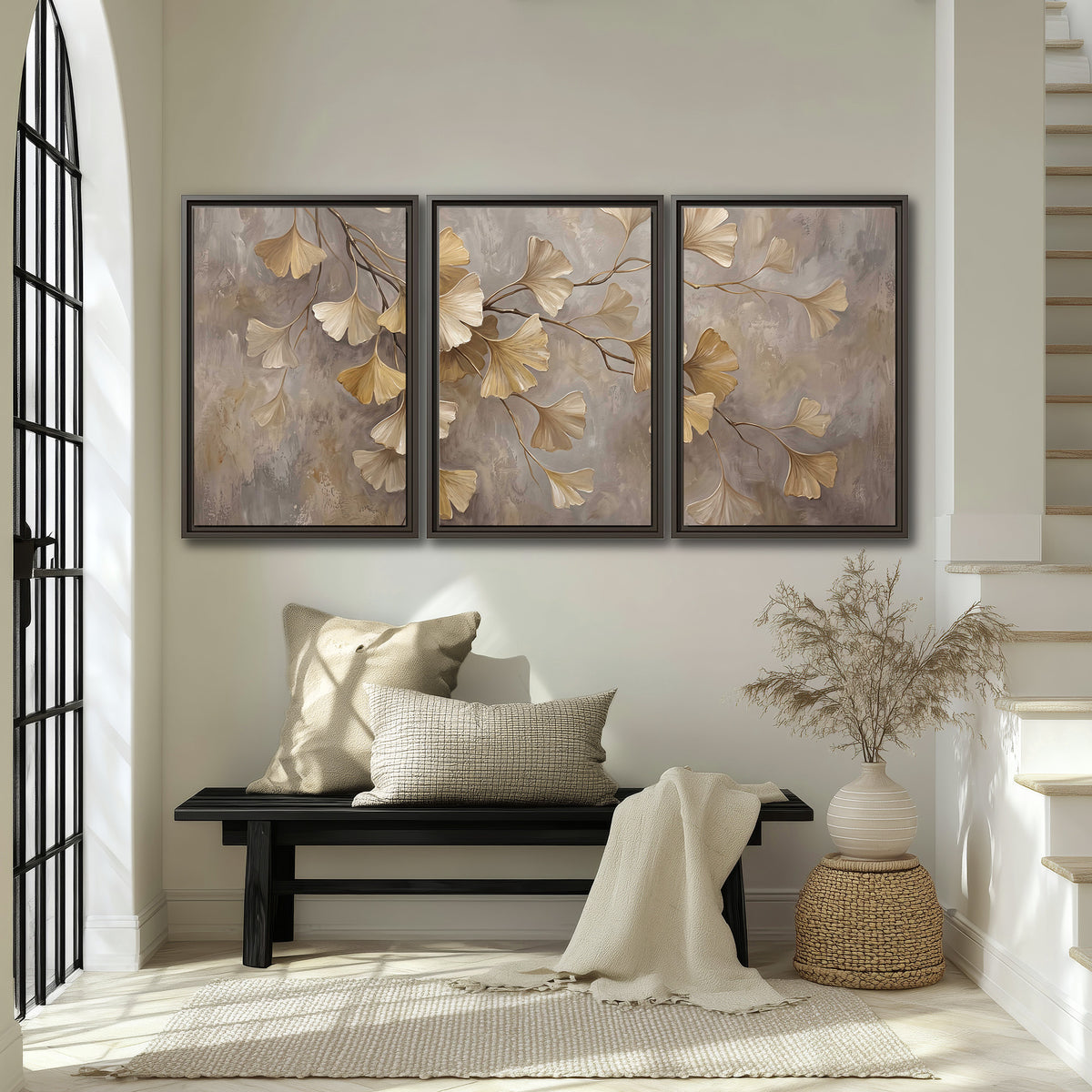Cream and gold-colored ginkgo leaves against warm gray 3 piece framed canvas wall art displayed in a entryway