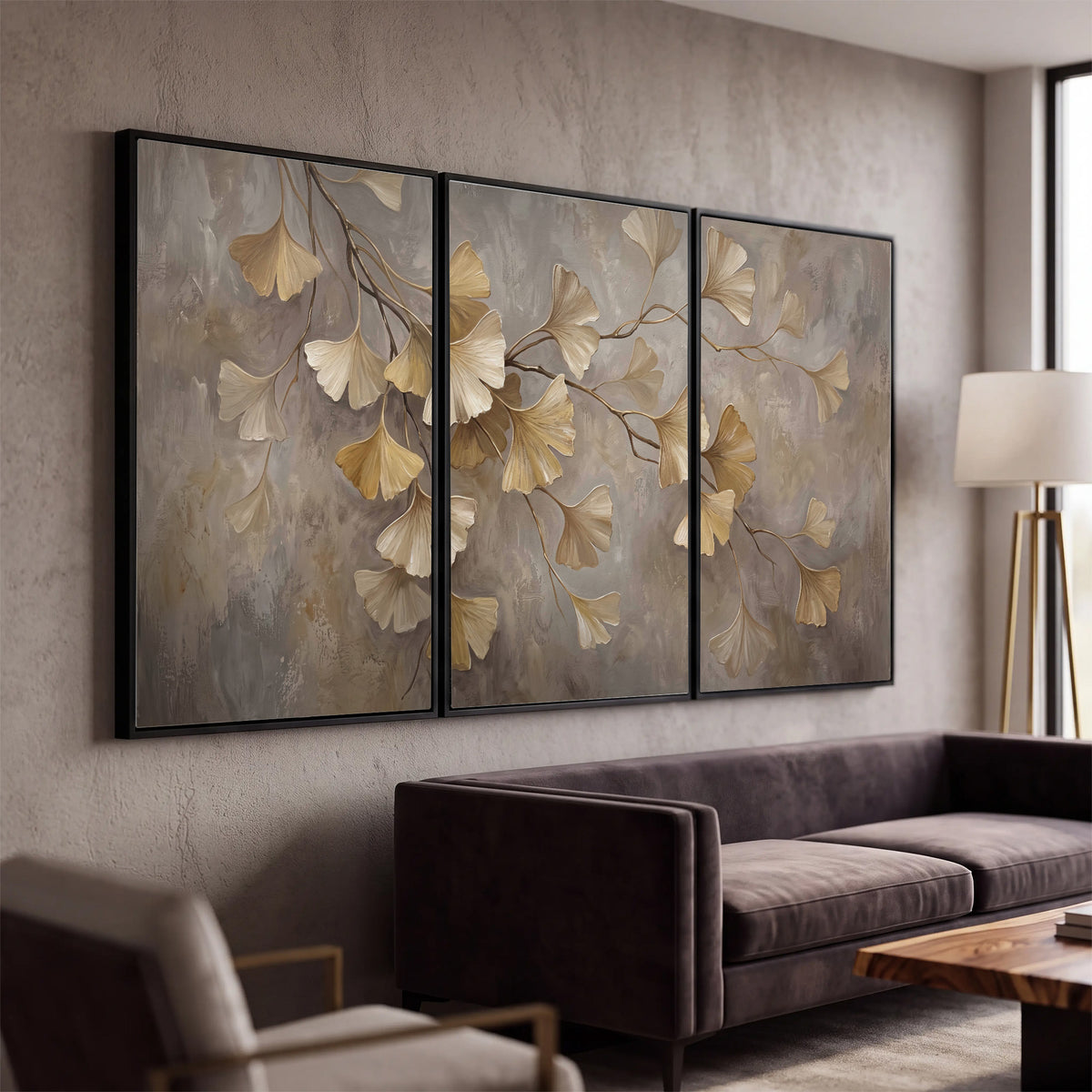 Cream and gold-colored ginkgo leaves against warm gray 3 piece framed canvas wall art displayed in a modern living room