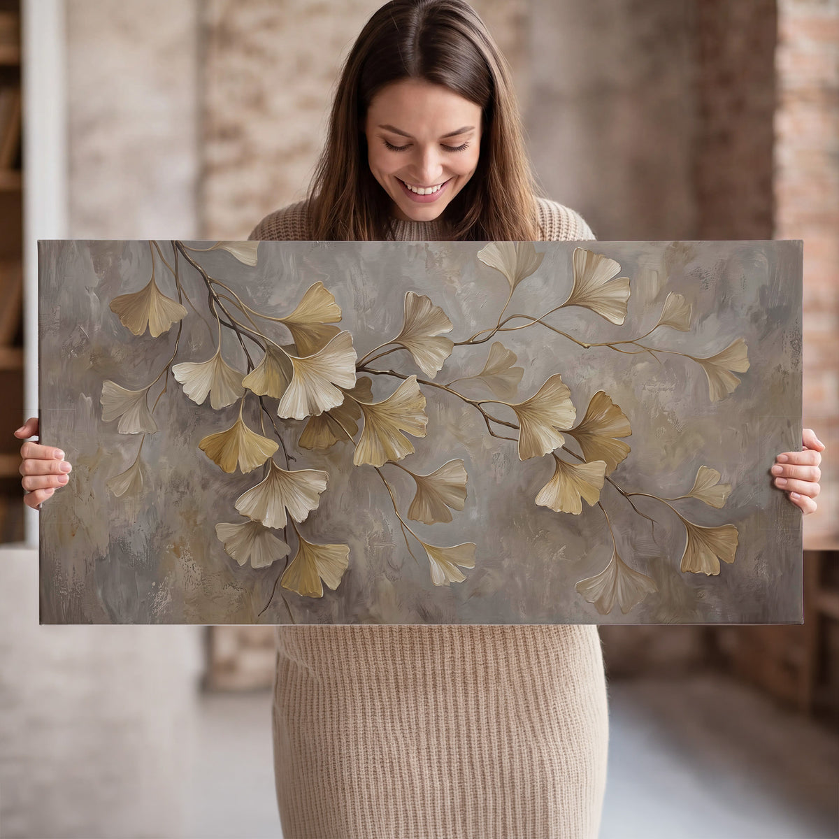 Cream and gold-colored ginkgo leaves against warm gray single canvas wall art held in hands