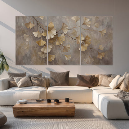 Cream and gold-colored ginkgo leaves against warm gray set of 3 poster prints displayed in a living room