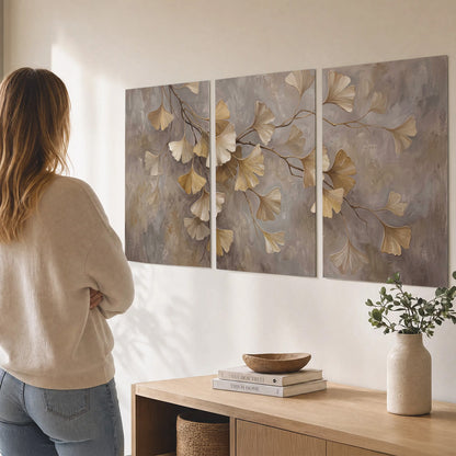Cream and gold-colored ginkgo leaves against warm gray set of 3 poster prints three panel arrangement on a wall