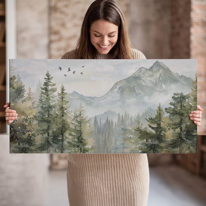 Soft green mountain peaks and evergreen trees beneath birds single canvas wall art held in hands