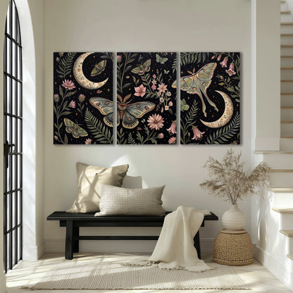 Decorative moths, crescent moons and flowers on black 3 piece canvas wall art displayed in a entryway