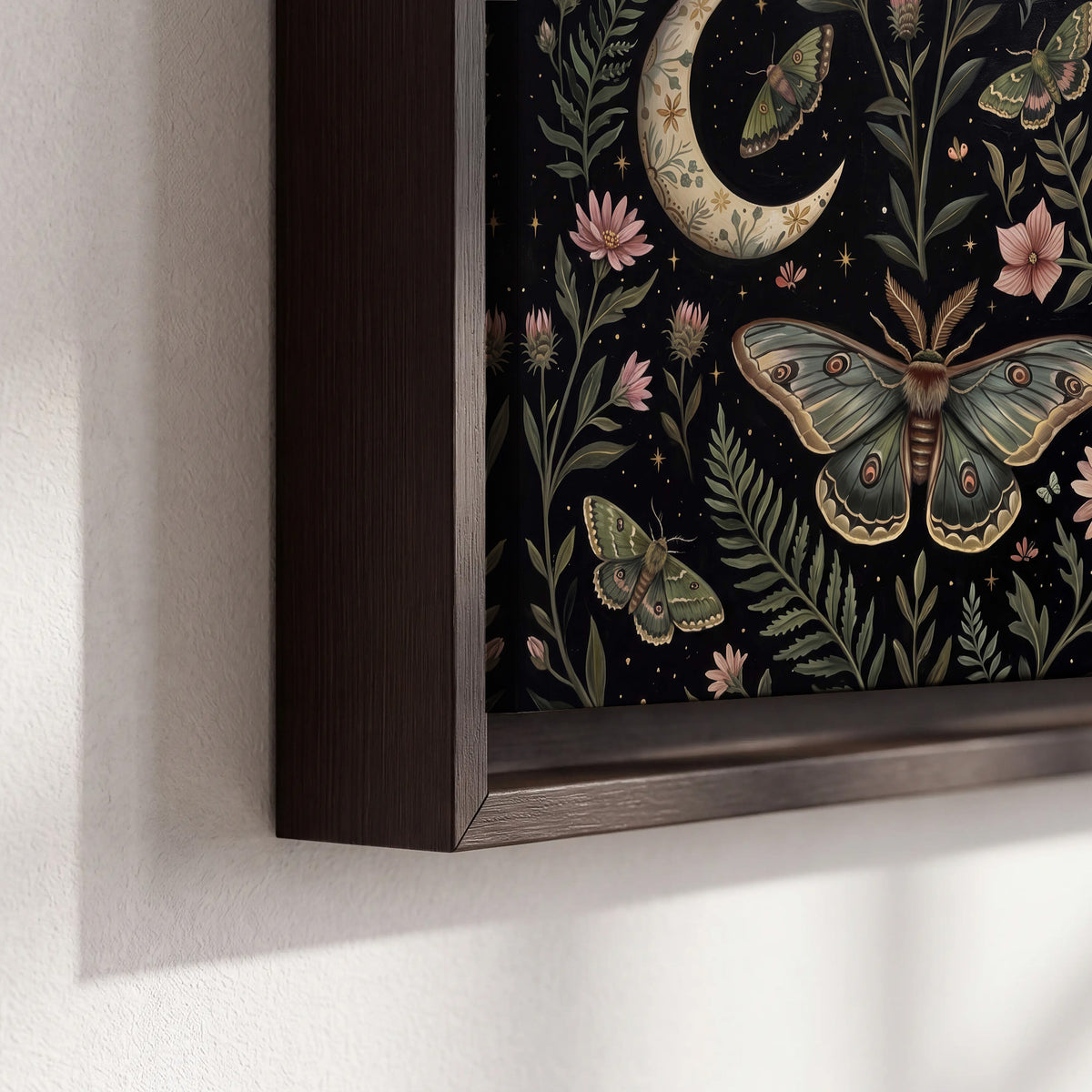 Decorative moths, crescent moons and flowers on black 3 piece framed canvas wall art material and edge close up