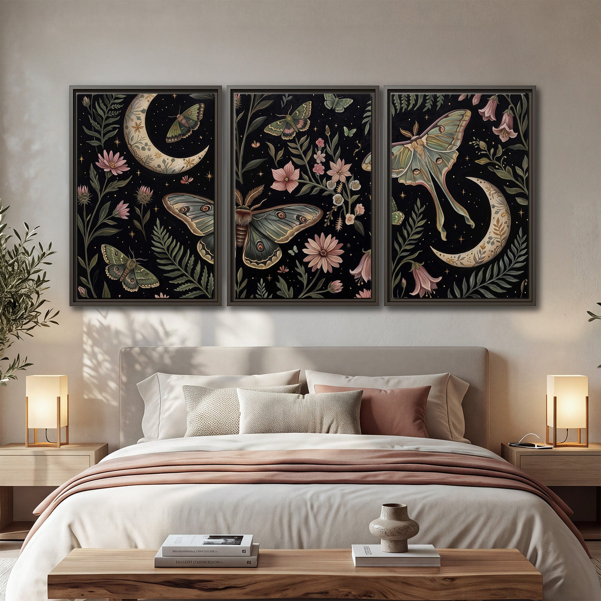 Decorative moths, crescent moons and flowers on black 3 piece framed canvas wall art displayed in a bedroom