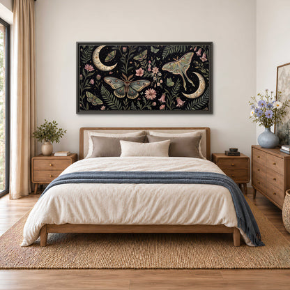Decorative moths, crescent moons and flowers on black single framed canvas wall art styled in an interior