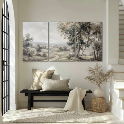 A quiet winding road through gray-green rolling hills 3 piece canvas wall art displayed in a entryway