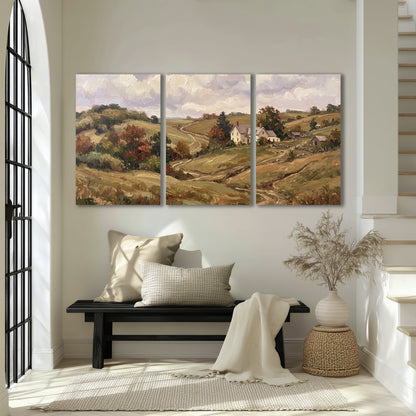 Warm rolling fields and countryside cottages beneath soft clouds 3 piece canvas wall art displayed in a entryway