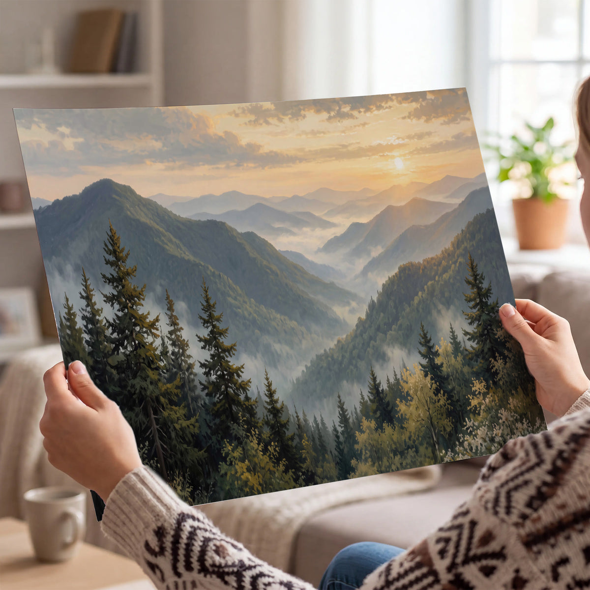 Blue-green mountain ridges and pines beneath a golden sunset single poster print held in hands