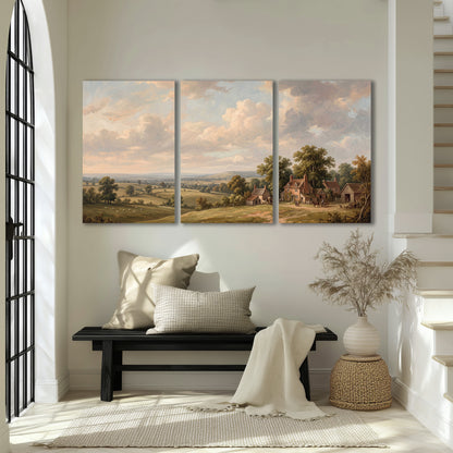 Small cottages overlooking fields beneath a luminous cloudy sky 3 piece canvas wall art displayed in a entryway