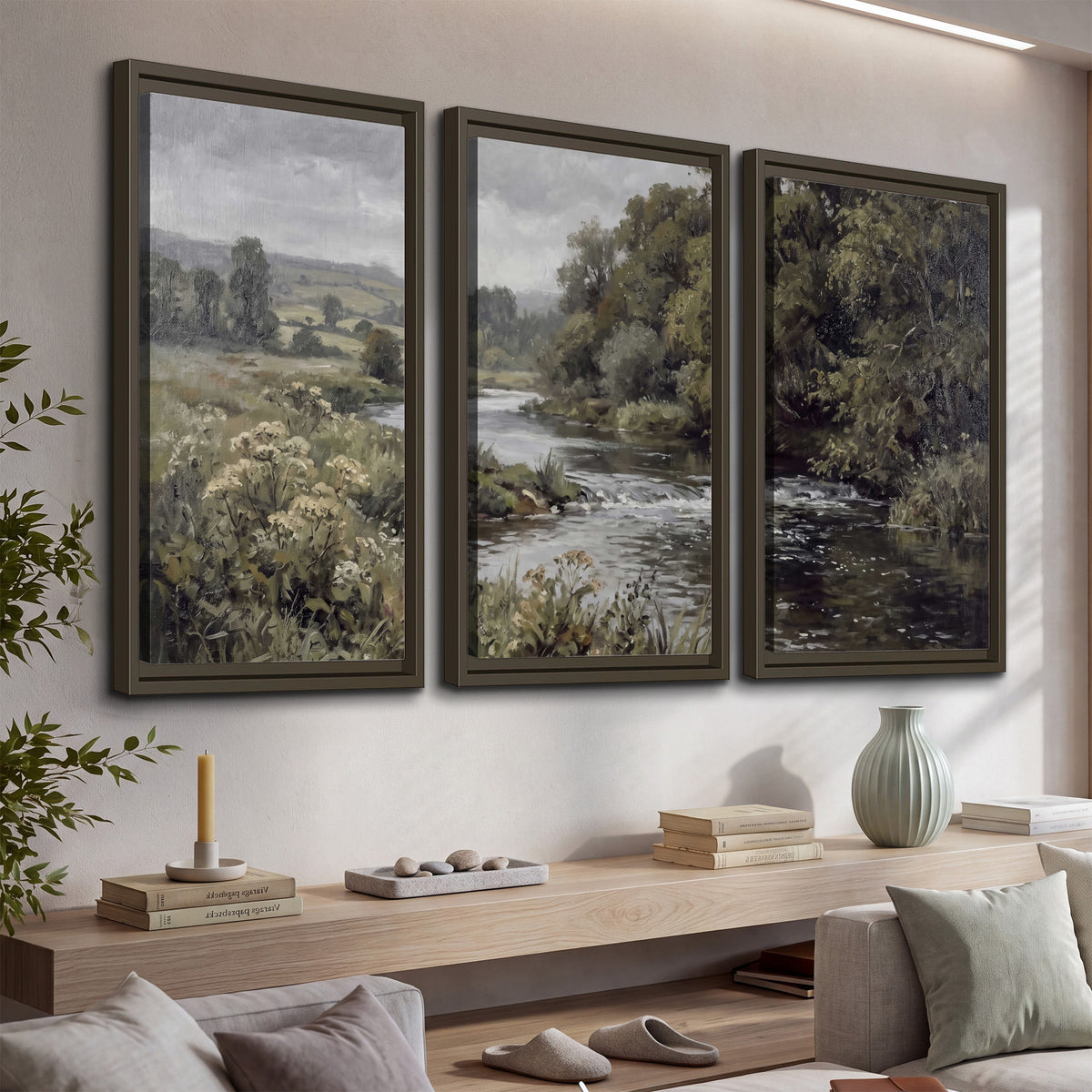 A gently flowing river bordered by olive-green trees and flowers 3 piece framed canvas wall art displayed in a console
