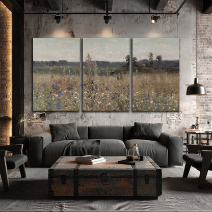 A loose painterly meadow with scattered blue and white wildflowers 3 piece canvas wall art displayed in a industrial room