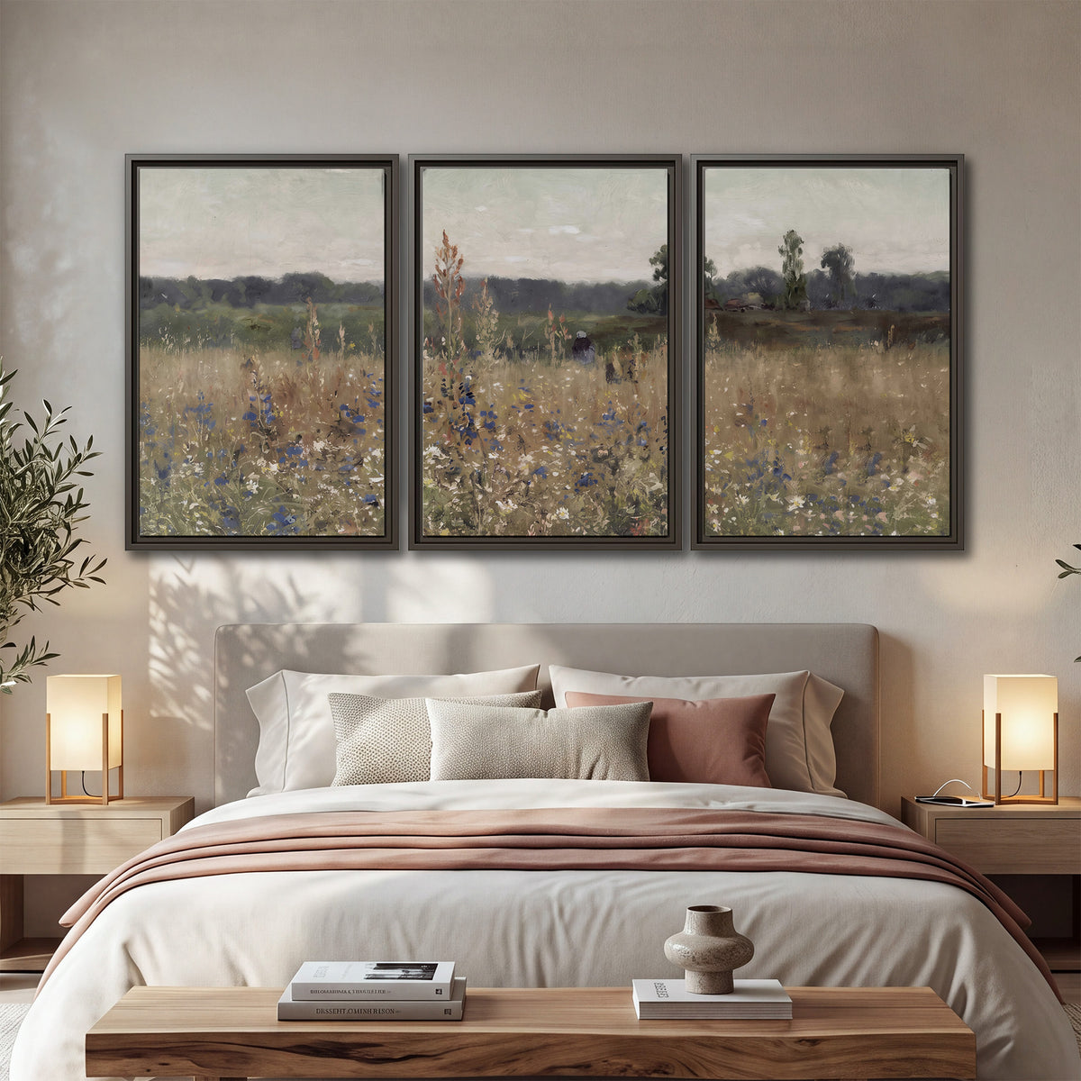 A loose painterly meadow with scattered blue and white wildflowers 3 piece framed canvas wall art displayed in a bedroom
