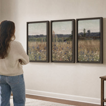 A loose painterly meadow with scattered blue and white wildflowers 3 piece framed canvas wall art three panel arrangement on a wall
