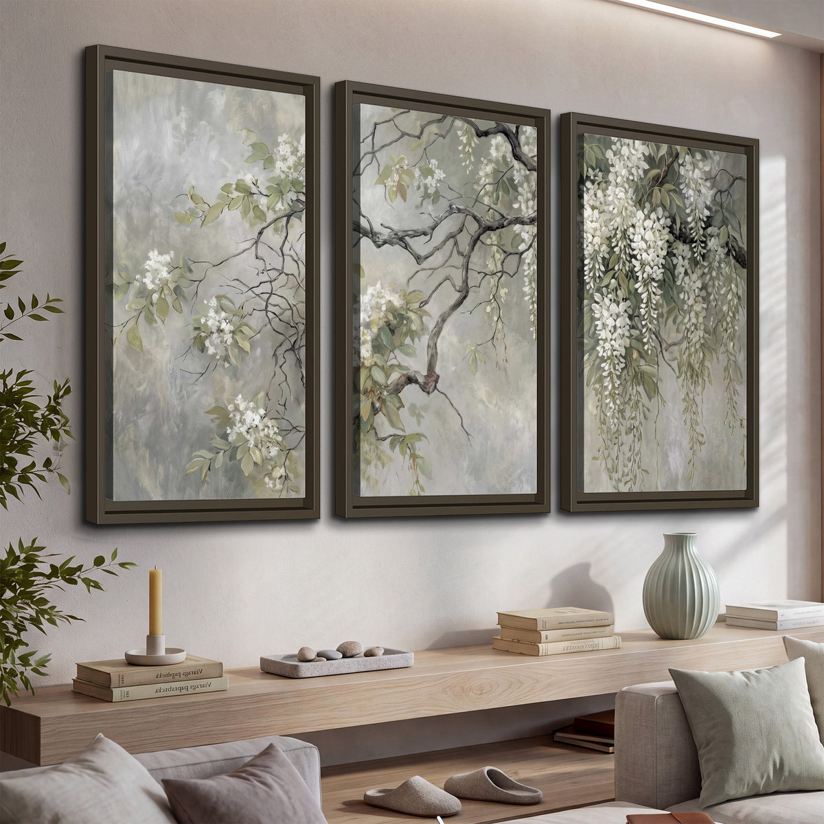 Trailing white blossoms and delicate green branches on pale gray 3 piece framed canvas wall art displayed in a console