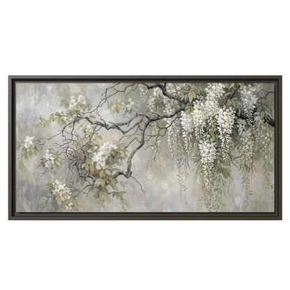 Trailing white blossoms and delicate green branches on pale gray single framed canvas wall art viewed straight on
