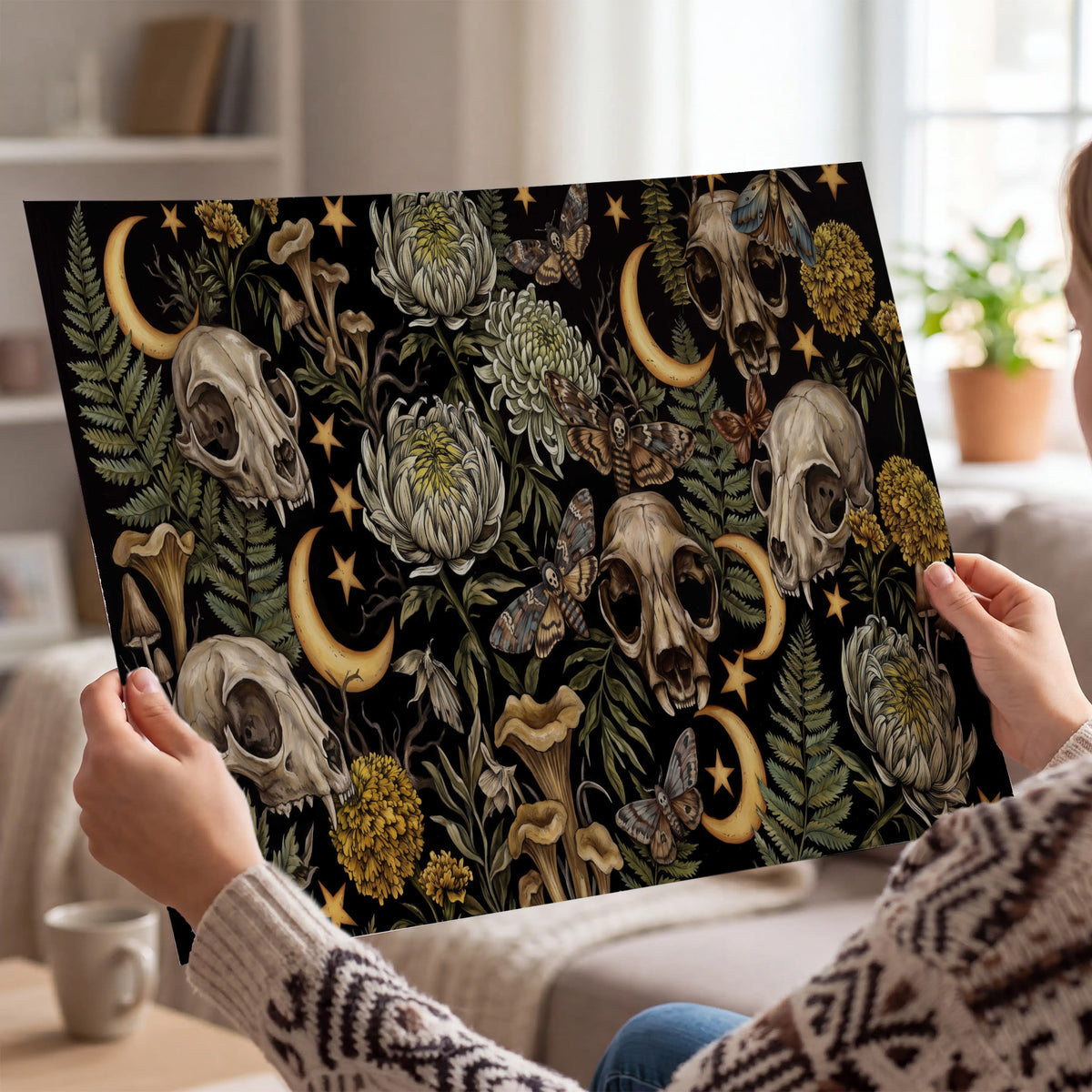 Decorative animal skulls, moons, stars, mushrooms and botanical leaves single poster print held in hands
