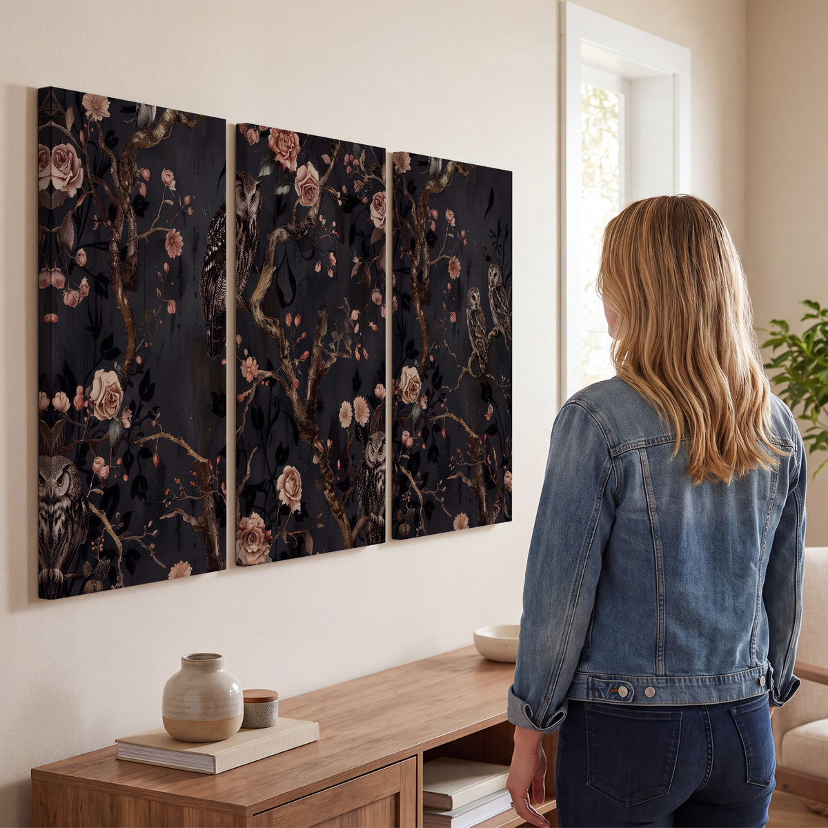 Owls among curling branches and dusty pink flowers on dark gray 3 piece canvas wall art three panel arrangement on a wall
