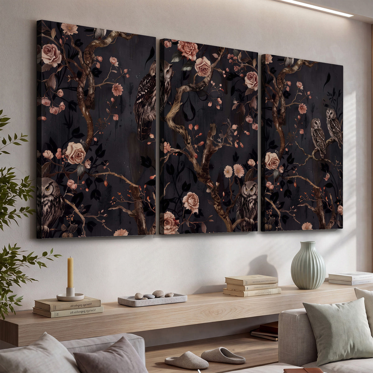 Owls among curling branches and dusty pink flowers on dark gray 3 piece canvas wall art displayed in a console