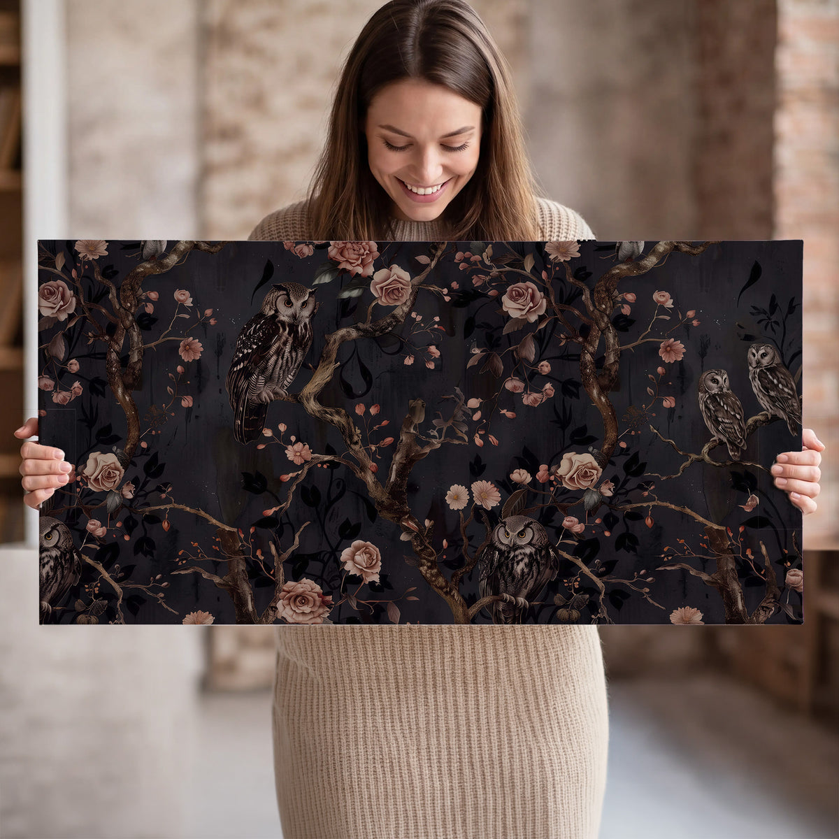 Owls among curling branches and dusty pink flowers on dark gray single canvas wall art held in hands