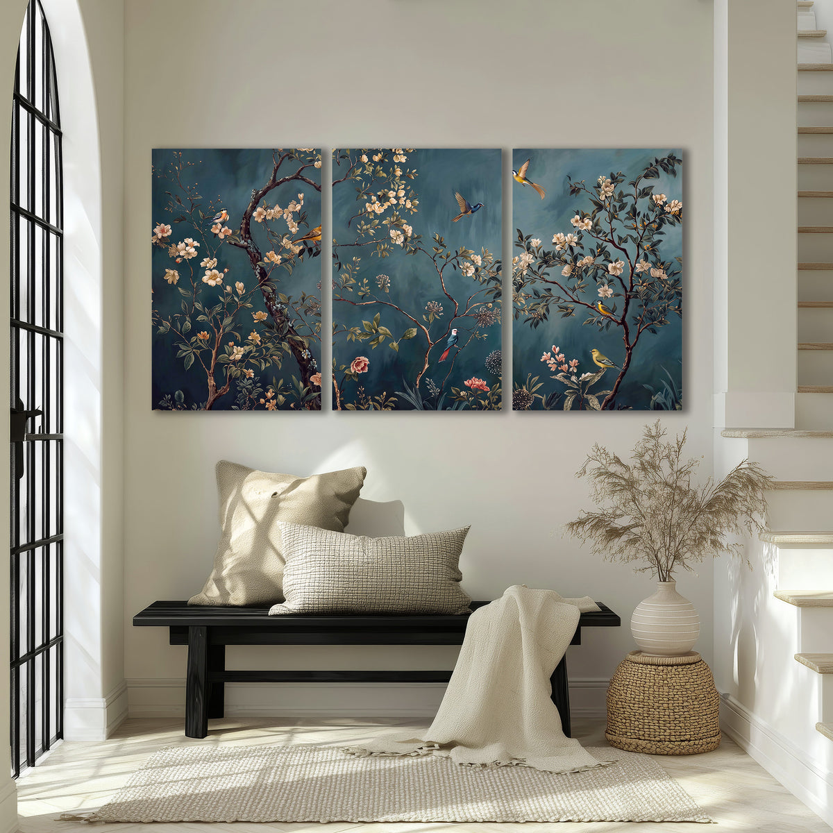 Colorful birds and pale blossoms on branches against teal blue 3 piece canvas wall art displayed in a entryway