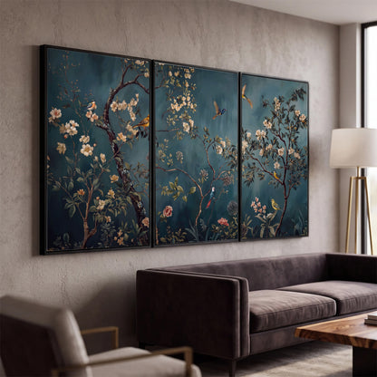 Colorful birds and pale blossoms on branches against teal blue 3 piece framed canvas wall art displayed in a modern living room