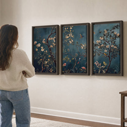 Colorful birds and pale blossoms on branches against teal blue 3 piece framed canvas wall art three panel arrangement on a wall