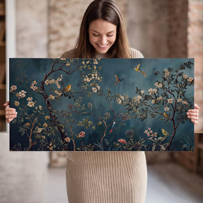Colorful birds and pale blossoms on branches against teal blue single canvas wall art held in hands