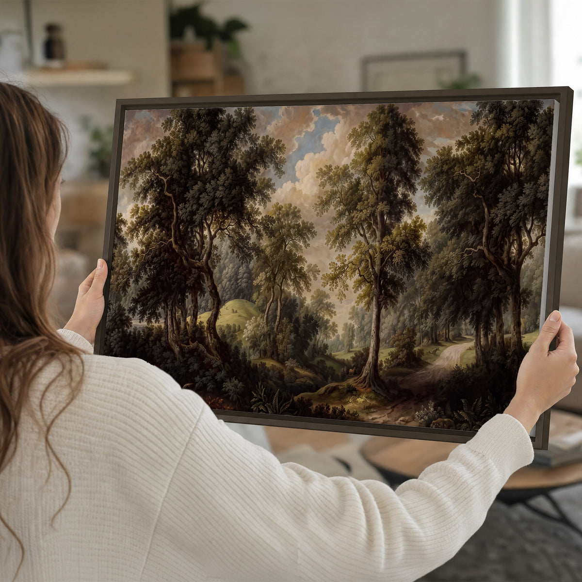 Old trees framing a softly lit woodland path single framed canvas wall art held in hands