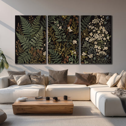 Layered green ferns and delicate cream flowers on a black background 3 piece canvas wall art displayed in a living room