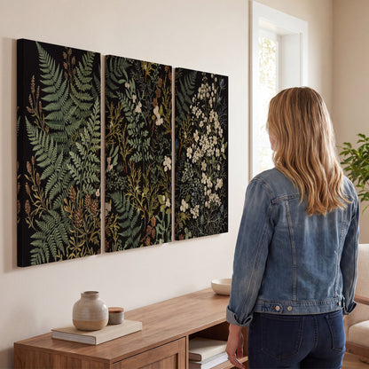 Layered green ferns and delicate cream flowers on a black background 3 piece canvas wall art three panel arrangement on a wall