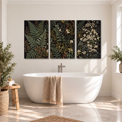 Layered green ferns and delicate cream flowers on a black background 3 piece canvas wall art styled in an interior