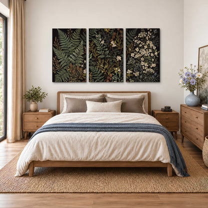 Layered green ferns and delicate cream flowers on a black background 3 piece canvas wall art styled in an interior