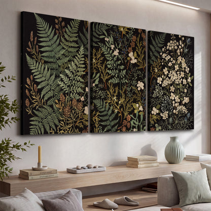 Layered green ferns and delicate cream flowers on a black background 3 piece canvas wall art displayed in a console