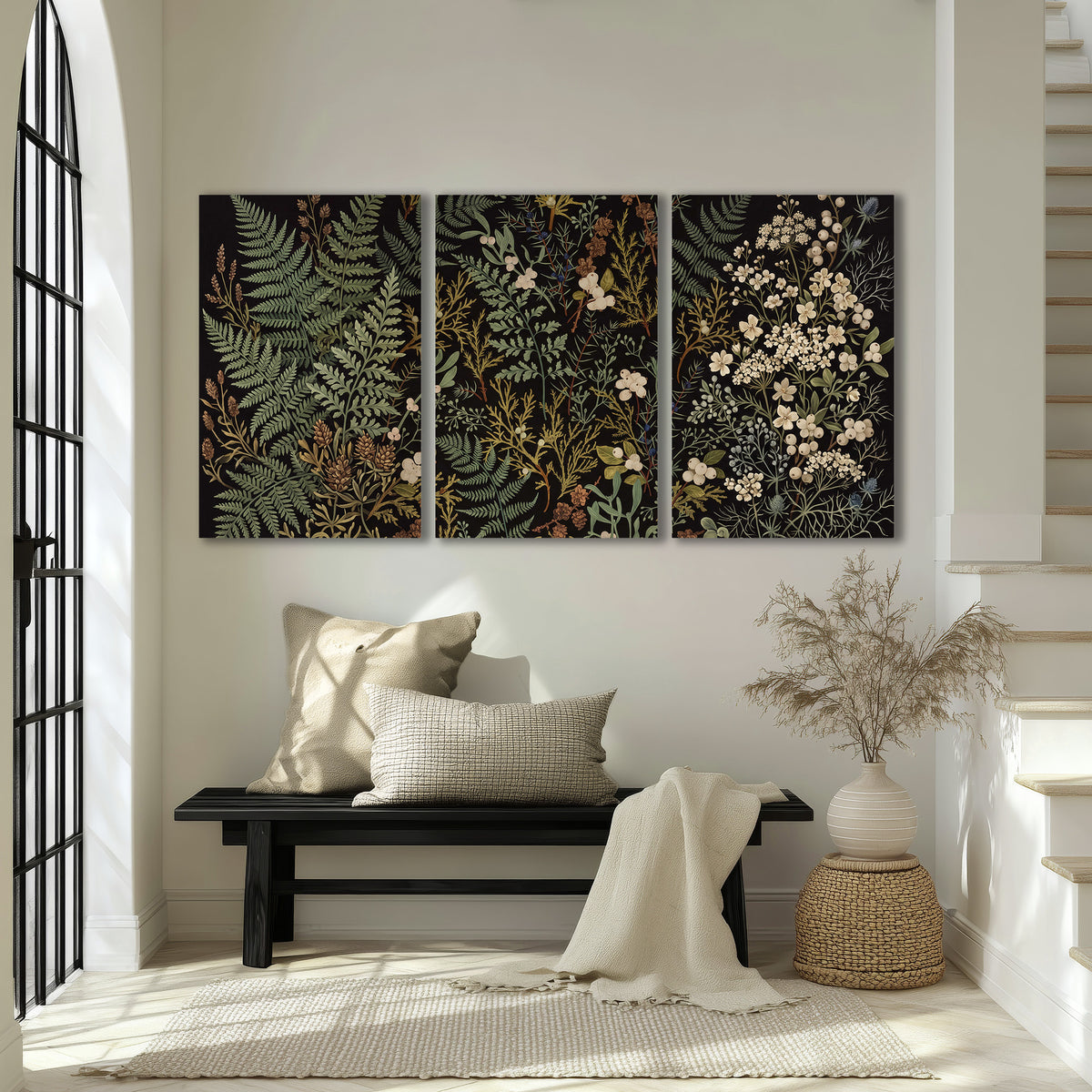 Layered green ferns and delicate cream flowers on a black background 3 piece canvas wall art displayed in a entryway