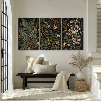 Layered green ferns and delicate cream flowers on a black background 3 piece canvas wall art displayed in a entryway
