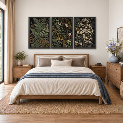 Layered green ferns and delicate cream flowers on a black background 3 piece framed canvas wall art styled in an interior