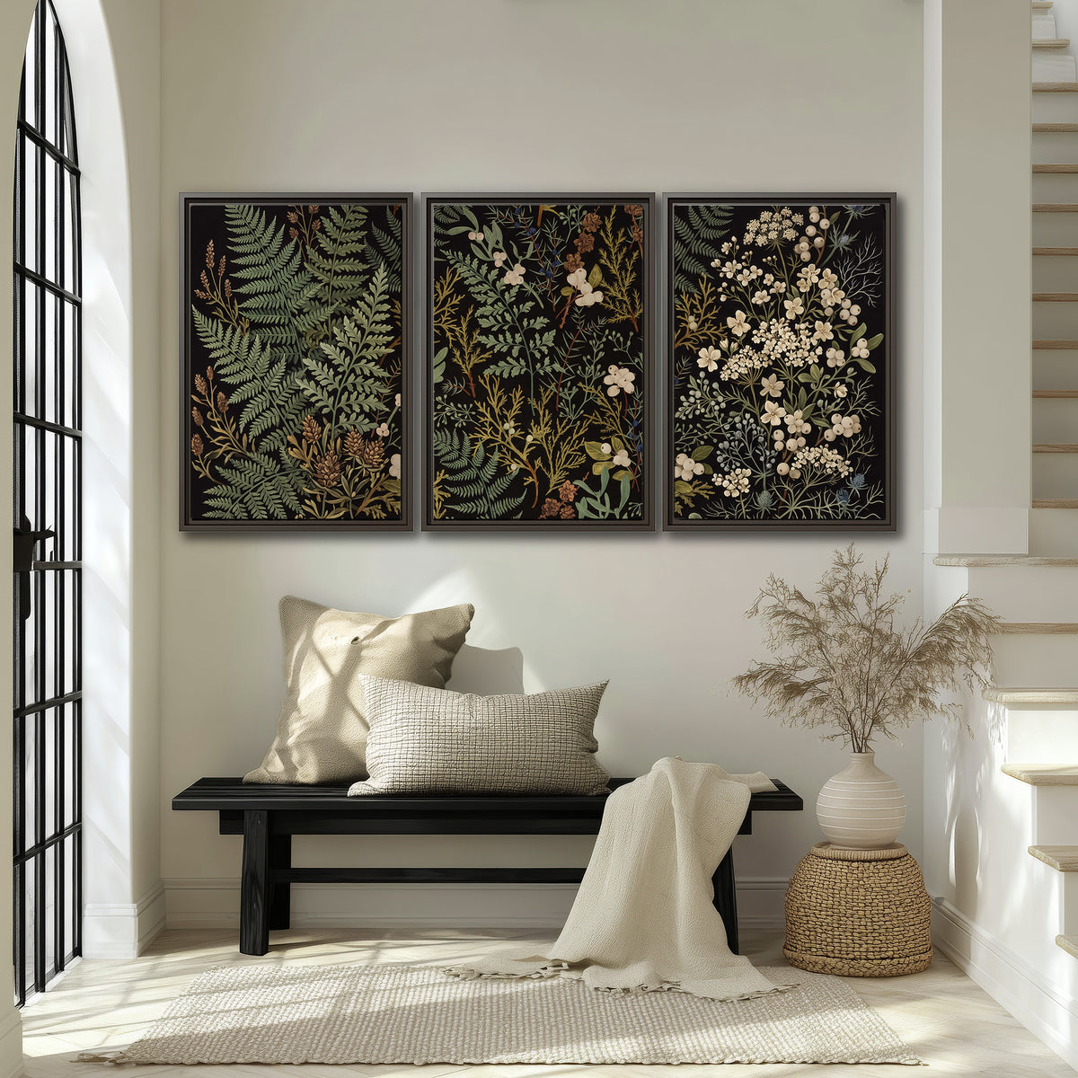 Layered green ferns and delicate cream flowers on a black background 3 piece framed canvas wall art displayed in a entryway