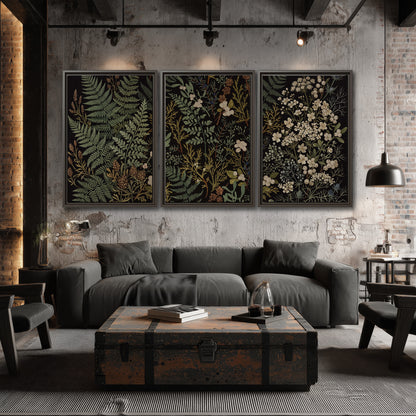 Layered green ferns and delicate cream flowers on a black background 3 piece framed canvas wall art displayed in a industrial room